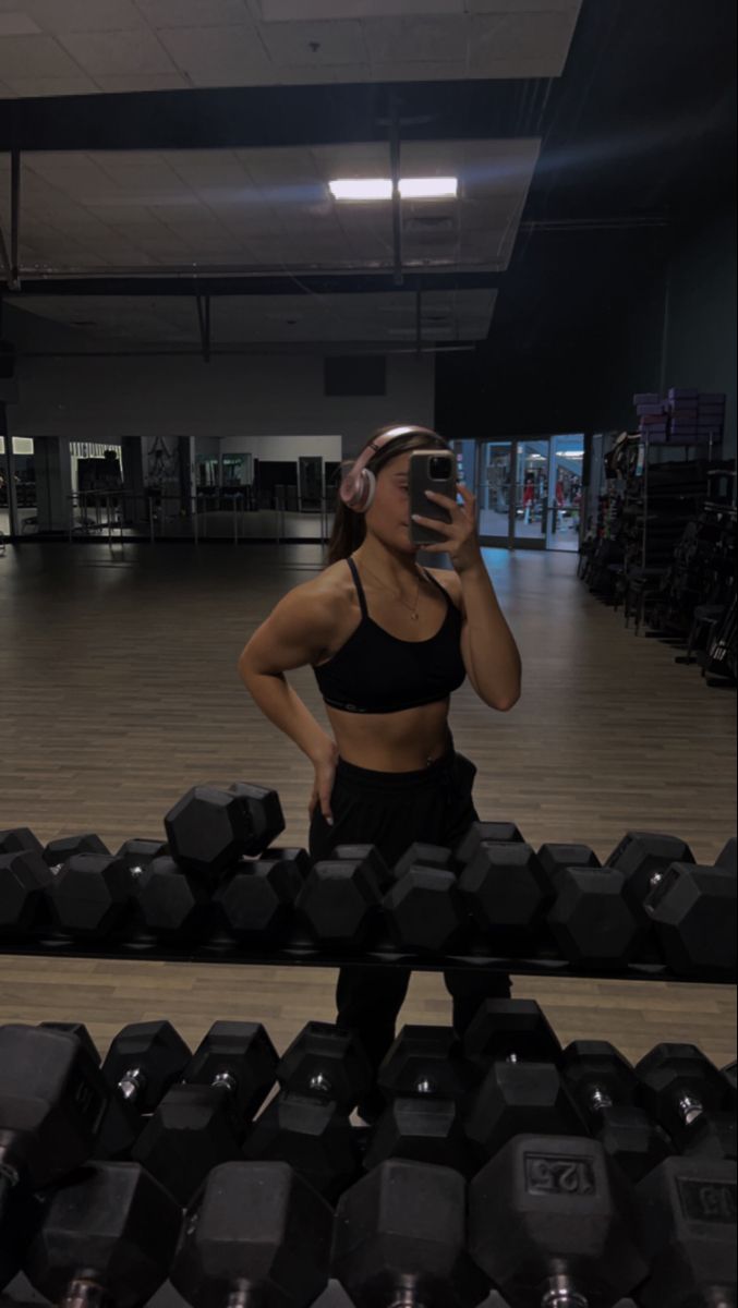 Cardio na rowerze przez modelkę fitness Dziewczyna w bikini fitness pozuje na rowerze stacjonarnym z potem na skórze