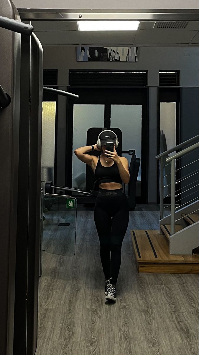 Przygotowanie shake'a przez modelkę fitness Modelka miesza proteinowy shake w kuchni ubrana w krótki top sportowy i szorty