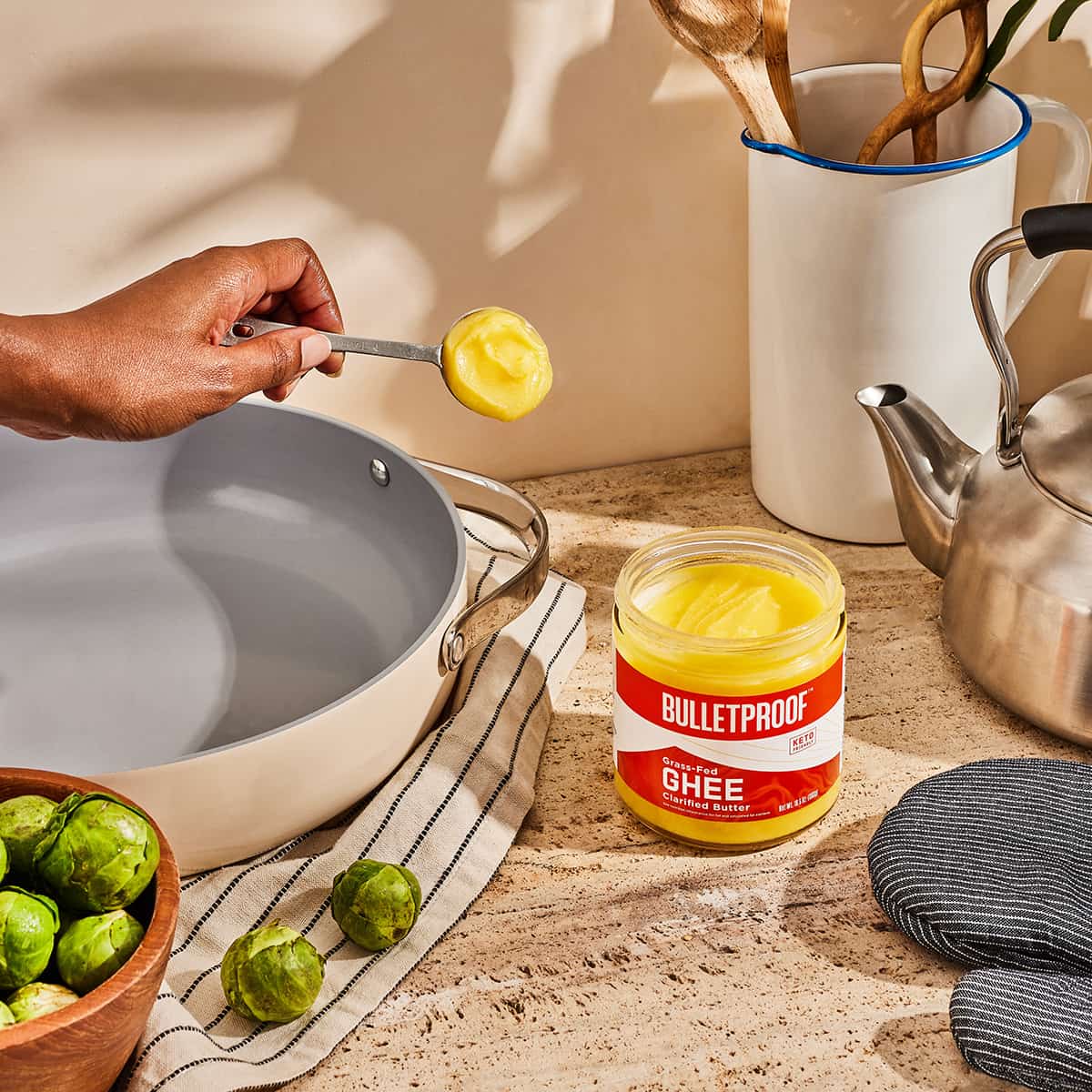 Ghee w tradycyjnej ajurwedyjskiej kuchni hinduska kobieta nalewa ghee do glinianego naczynia w kuchni