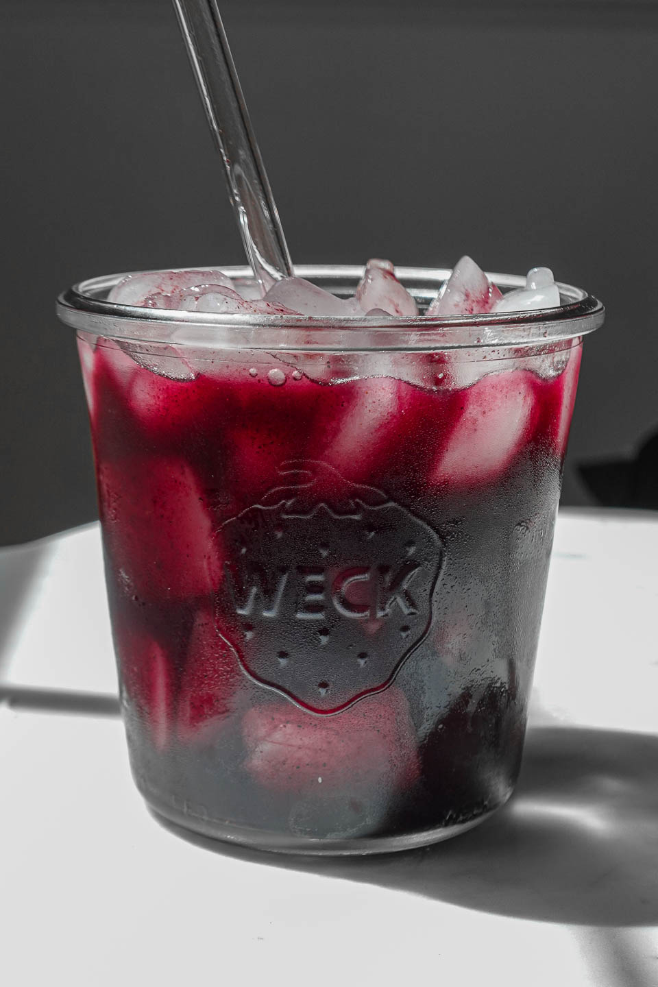 Szklanka z żółtym domowym izotonikiem, plaster cytryny i miód obok na stole