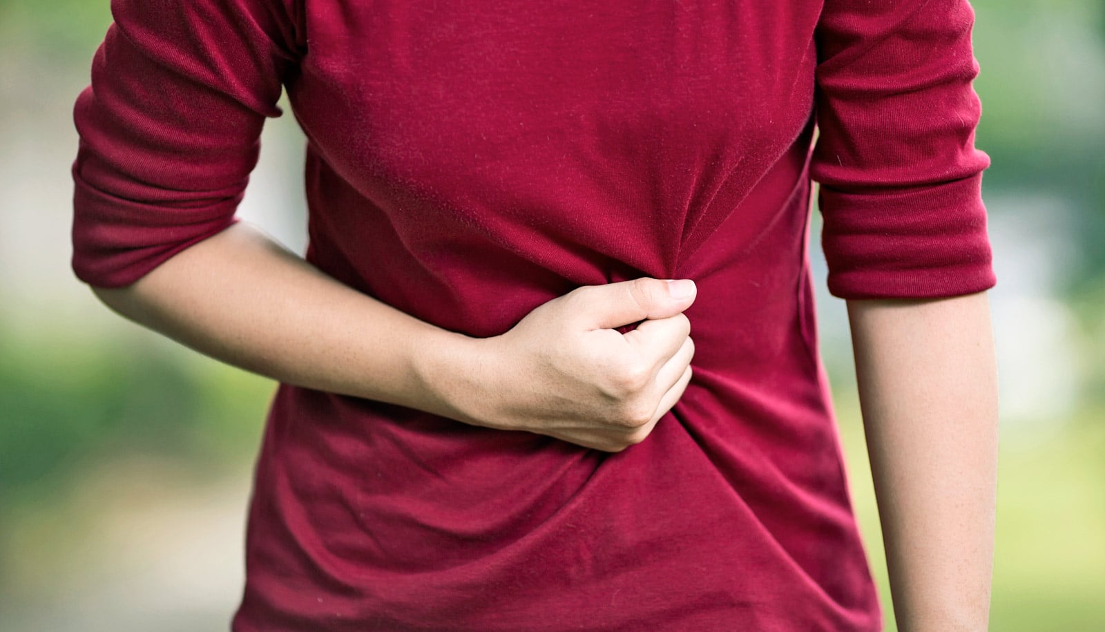 głębokie oddychanie na stres i ból mężczyzna oddycha głęboko z ręką na brzuchu na ławce w parku